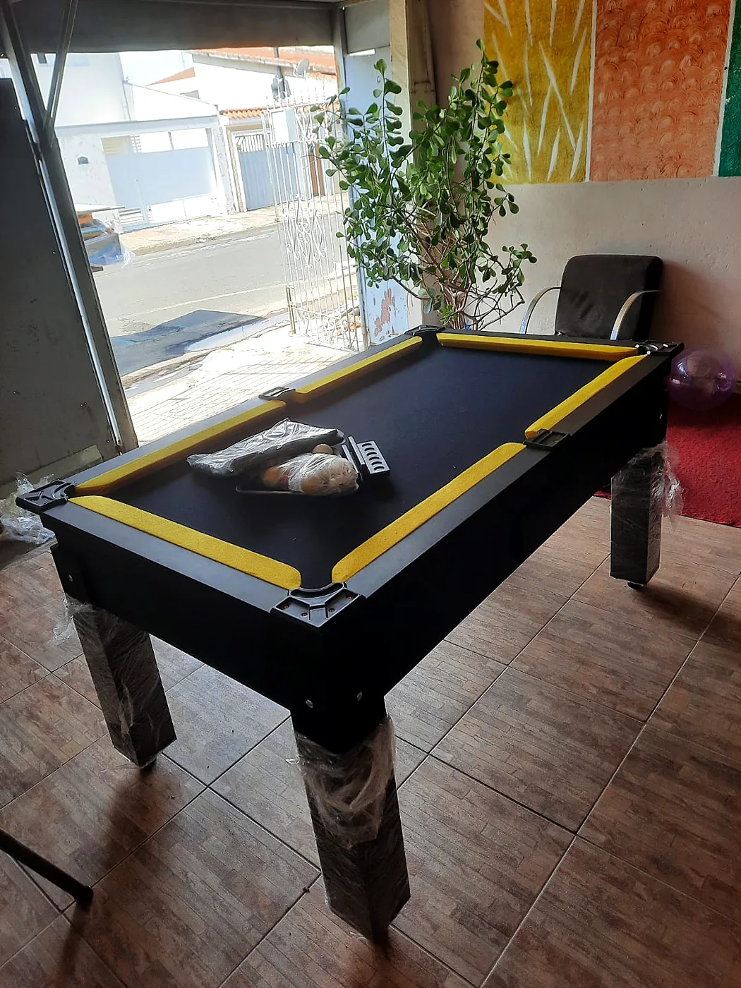 Mesa de bilhar com detalhes amarelos em ambiente real