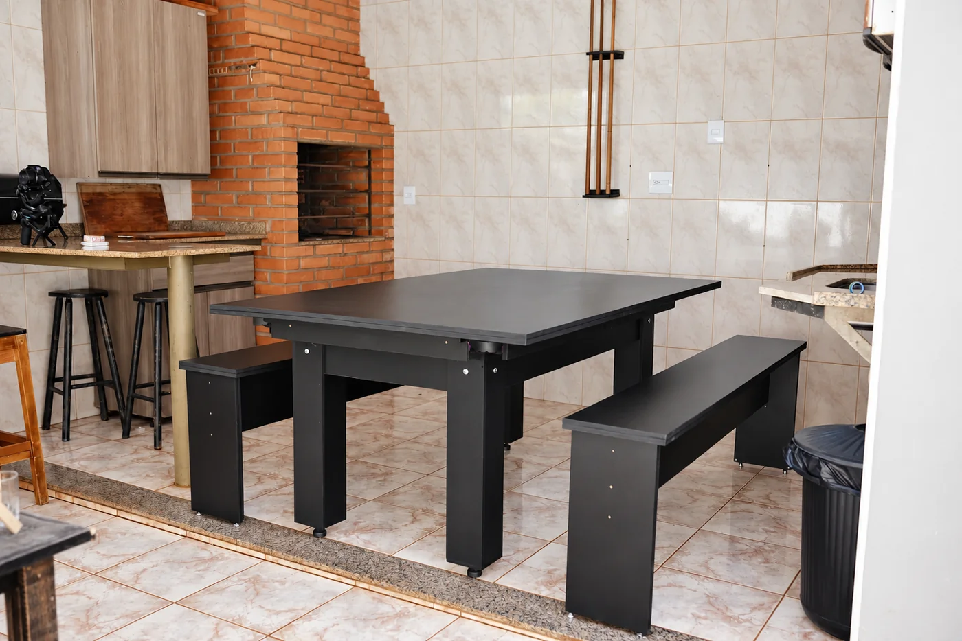Mesa de bilhar com tampo para jantar e bancos em ambiente gourmet