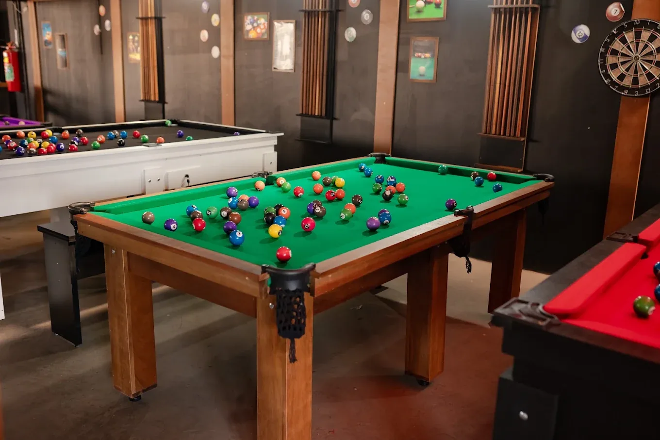 Mesas de bilhar de diferentes cores em um ambiente de jogos